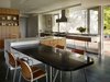 Modern home with Kitchen, Range Hood, Wood Cabinet, Marble Counter, Range, Ceramic Tile Floor, and Undermount Sink. Two sinks with angular faucets make this white and wood kitchen island the main prep area in this California kitchen. A long kitchen table protrudes out from the island in a contrasting dark stone with polished nickel legs for a strong visual demarcation between the island and the table, although the two are physically connected. Photo 9 of Shou Sugi Ban House