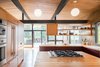 Modern home with Kitchen, Medium Hardwood Floor, Wood Counter, Refrigerator, Cooktops, Wood Cabinet, Wall Oven, Pendant Lighting, Open Cabinet, and Drop In Sink. The kitchen now looks out to the big, open deck which houses expansive tree views.
Photo 8 of Hillside Midcentury