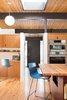 Modern home with Kitchen, Wood Cabinet, Wood Counter, Wall Oven, and Medium Hardwood Floor. The front door leads straight into the kitchen, a central gathering place. Photo 9 of Hillside Midcentury