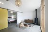 Modern home with Living Room, Concrete Floor, Console Tables, End Tables, Pendant Lighting, Chair, Wall Lighting, Media Cabinet, Wood Burning Fireplace, and Rug Floor. When moved the sliders expose the bedroom. Photo 2 of Stable Conversion