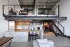 Modern home with Kitchen, Concrete Floor, Refrigerator, Concrete Backsplashe, Wood Cabinet, Wood Counter, Drop In Sink, Cooktops, Range Hood, and Range. Inserting a mix of texture, raw materials and functional elements, SHED Architecture & Design was able to artfully marry the new additions with the original industrial construction using a palette of concrete brick, stainless steel plate, blackened steel and mirror. Photo of Capitol Hill Loft