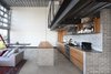Modern home with Kitchen, Wood Cabinet, Range, Wall Oven, Wood Counter, Concrete Floor, Concrete Backsplashe, Refrigerator, Cooktops, and Range Hood. The geometric wallpaper by local designer Brian Paquette adds subtle texture and movement to the space. Inspired by a traditional Japanese pattern book, the design was reproduced on 11x17 paper and applied to the wall using wheat paste. Photo 3 of Capitol Hill Loft