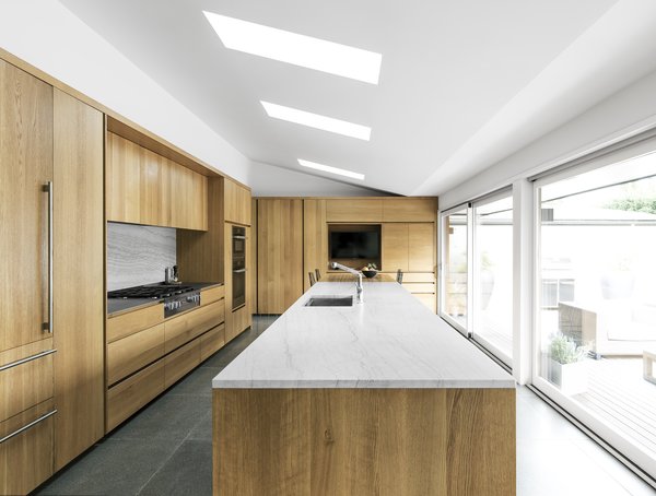 Wood cabinetry wraps the kitchen, and oversized sliding doors open to the expansive deck. Skylights fill the space with natural light&mdash;a necessity with Seattle's gray winter skies.