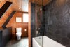 Modern home with Trees, Front Yard, Small Patio, Porch, Deck, Wood Patio, Porch, Deck, Table, Bar, Carpet Floor, Bed, Engineered Quartz Counter, Slate Floor, Range, One Piece Toilet, Ceramic Tile Backsplashe, Sofa, Chair, Coffee Tables, Floor Lighting, and Bath Room. Bathroom Photo 7 of Homewood