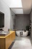 Here is the main bathroom located at the rear of the original dwelling's footprint. This area boasts an acrylic render finish to the walls, as well as a vaulted skylight that has been carved within the original roof. Photo 13 of Binary House modern home