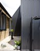 Modern home with Outdoor, Stone Patio, Porch, Deck, Metal Fences, Wall, Side Yard, Shower Pools, Tubs, Shower, Walkways, and Vertical Fences, Wall. The northern courtyard provides a secondary entry, as well as an outdoor shower. Photo 9 of Binary House