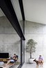 Modern home with Living Room, Concrete Floor, Chair, End Tables, Ottomans, and Shelves. Concealed internal retractable insect screens and external roller blinds are housed within fabricated steel head beams, which work in confluence with blinds concealed in upper soffit pockets to temper direct sunlight when required Photo 17 of Binary House