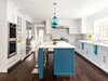Modern home with Kitchen, Medium Hardwood Floor, Pendant Lighting, White Cabinet, and Marble Counter. Two Condesa Stamen hang above the eat-in kitchen island. The burst of brightness from the blue glass pendants complement the soft accents of the island cabinetry and curtains. The blue stands out against an otherwise neutral palette of varying tones of whites and grays, adding a pop to this light and airy kitchen. Photo of Clark