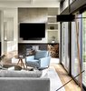 Modern home with Living Room, Light Hardwood Floor, Chair, Wood Burning Fireplace, and Floor Lighting. Double-Sided Fireplace in Family Room Photo 5 of Riverwoods