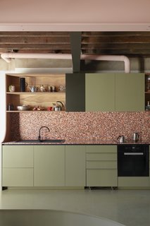 Kitchen, Tile Counter, Open Cabinet, and Colorful Cabinet Muted green cabinets pop against a pink-toned terrazzo backsplash.