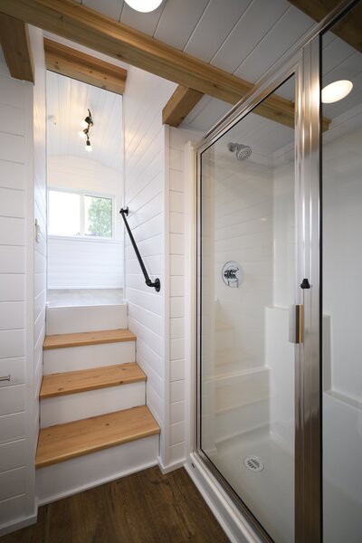 The bathroom features a shower with a glass door and a partial glass wall.