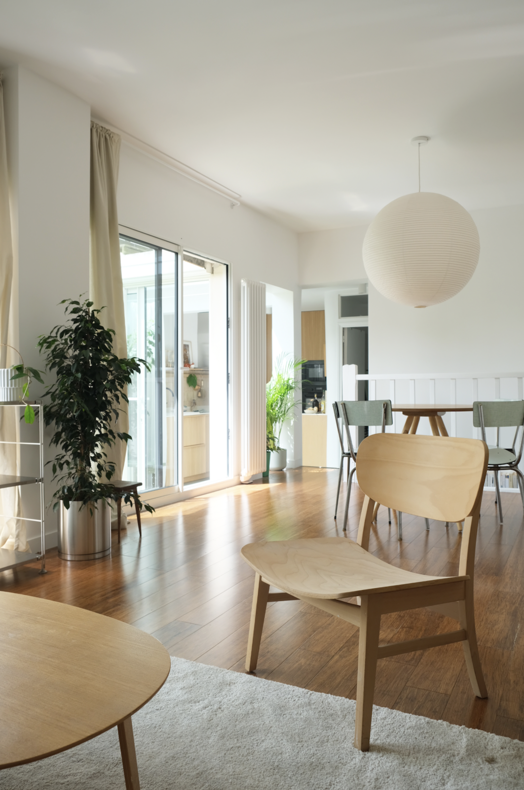 The open-plan living-and-dining rooms display oak flooring and modernist furniture pieces.
