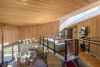 Modern home with Living Room, Pendant Lighting, Chair, Sofa, Recessed Lighting, and Medium Hardwood Floor. A long, slender skylight illuminates the top-floor lounge area. "The home’s location on the eastern slope of the creek ensures prolonged sunlight throughout the year, while also being optimally exposed to the prevailing rising air currents in the valley," states the firm. Photo 2 of A Sustainable Mountain Home in Chile Asks $1.36M