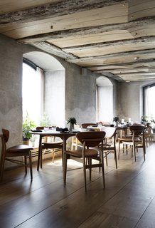 The ceiling is alternately composed of the original ceiling beams and new sculpted wooden planks, which are embedded with brass details. 
