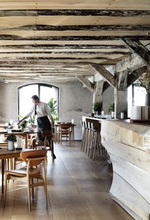 A massive carved wooden counter anchors the space, stretching from one room to the other. 
