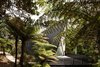 Modern home with Trees, Shrubs, Front Yard, Small Patio, Porch, Deck, Vertical Fences, Wall, Wood Fences, Wall, Exterior, House Building Type, Metal Siding Material, Metal Roof Material, and Cabin Building Type. On Waiheke Island near Auckland, New Zealand, the Tent House sits among wetlands on a patch of undeveloped land. It captures the back-to-basics simplicity of camping, thanks to architect Chris Tate.
Though he originally created the cabin to be a personal retreat/studio, Tate ended up experimenting with the design in order to challenge conventional expectations of what makes an ideal weekend escape. Now available for short-term rental, the one-bedroom, one-bathroom, 753-square-foot home includes a sleeping area on the mezzanine, a fully functional kitchen, an open-plan living area, and a front deck designed to Photo of The Tent House