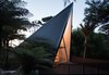 Modern home with Trees, Small Patio, Porch, Deck, Wood Fences, Wall, Front Yard, Vertical Fences, Wall, Exterior, House Building Type, and Metal Siding Material. The front deck was designed to Photo 8 of The Tent House