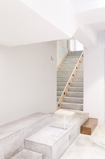 The cement floor in front of the bar becomes a multi-tier platform seating area. A cement staircase leads customers to additional seating on the second floor. 
