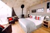 Modern home with Bedroom, Chair, Night Stands, Bed, Medium Hardwood Floor, and Table Lighting. The interior decor is inspired by a modern glamping lifestyle. Photo 6 of Whitepod Eco-Luxury Hotel