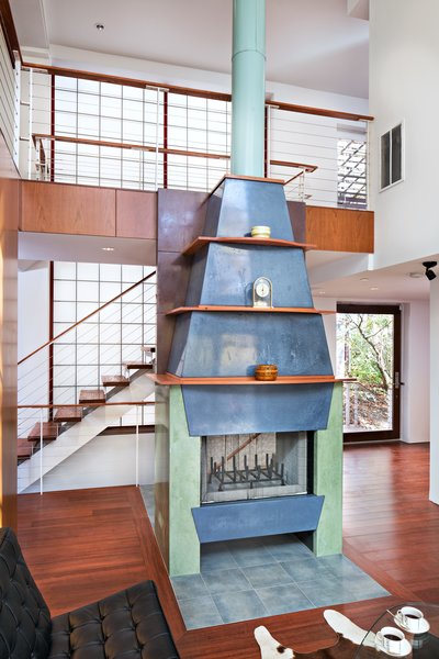 A fireplace assembled with three different colors on its concrete panels is the centerpiece of the spacious living area.