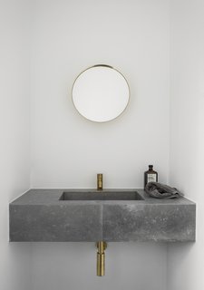 Both the kitchen and bathroom of the redesigned dwelling feature slim brass faucets. 