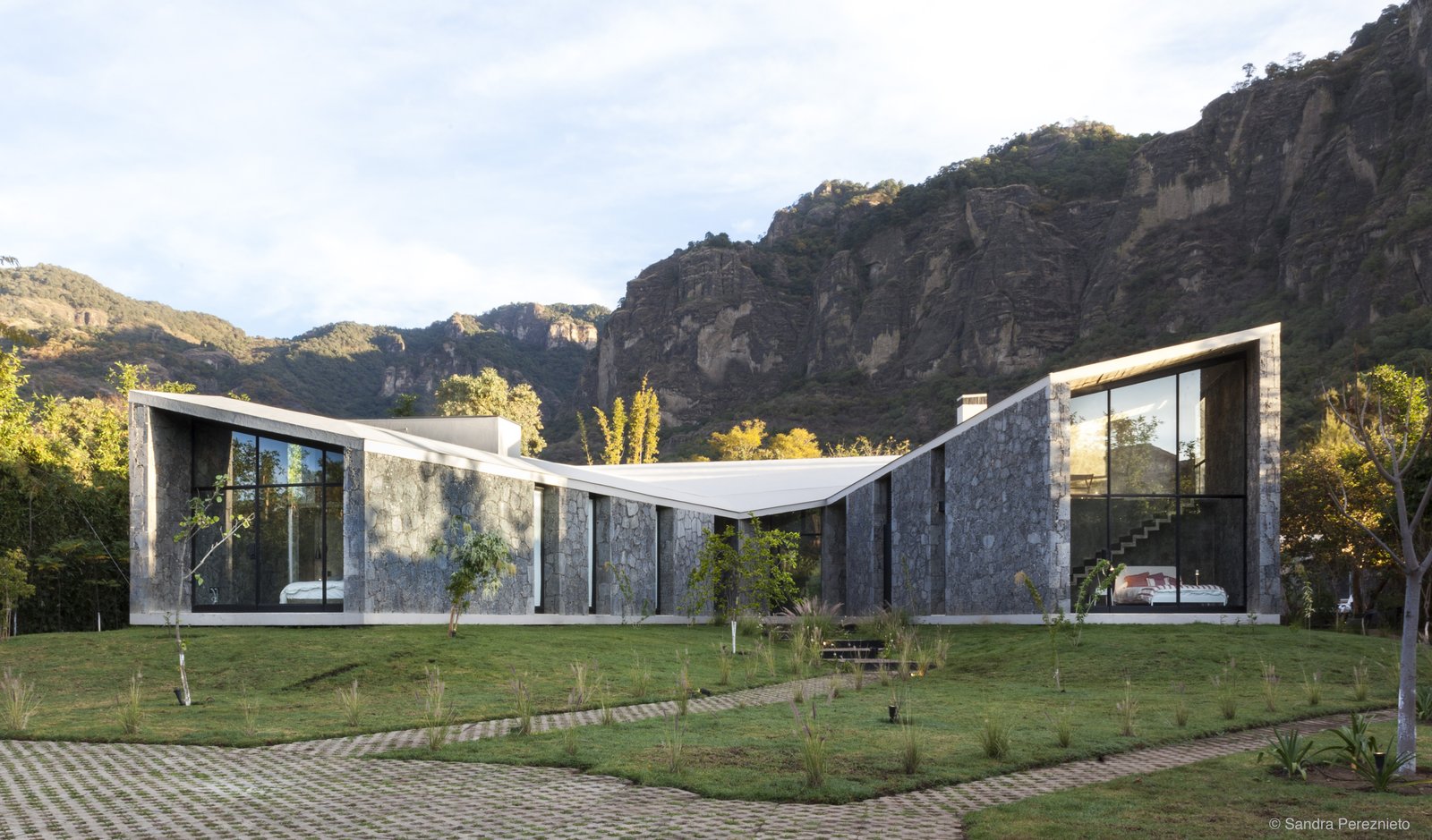 The house is a succession of three pavilions unified by a unique roof, with two covered patios.