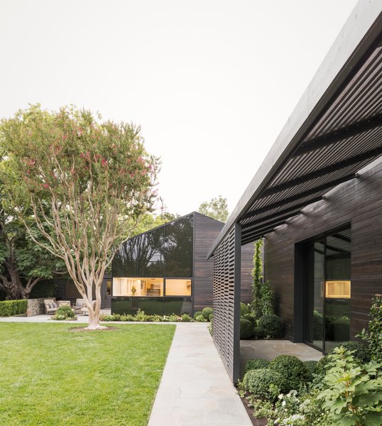 The addition is clad in contemporary-looking fritted glass and shou sugi ban—rustic charred wood—by Delta Millworks. Both materials contrast with the historic stonework of the original building.