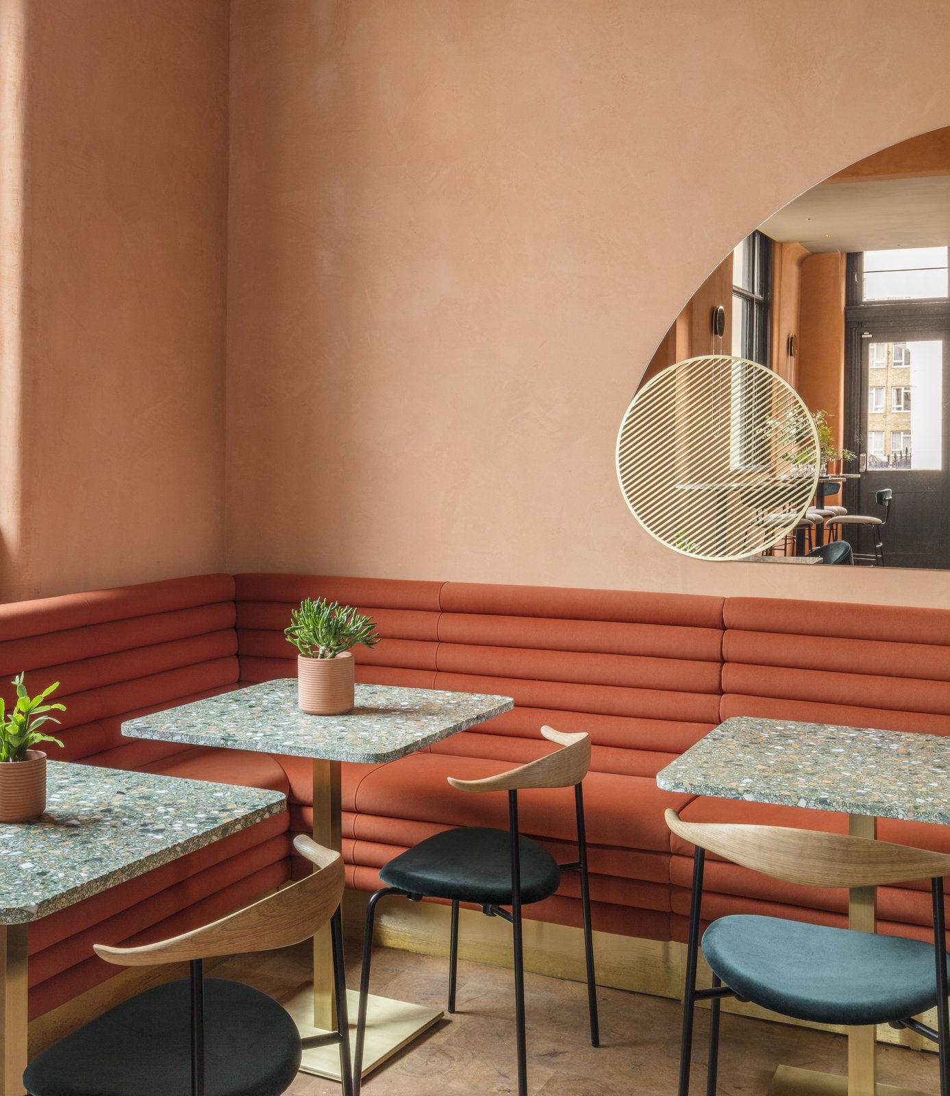 Custom-made rust-colored tubular suede banquettes accentuate the sunny color-palette.