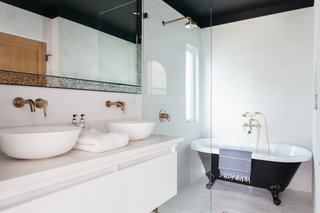 The ensuite bathroom in the master has a dual vanity and a vintage claw-foot tub installed in the open shower. 