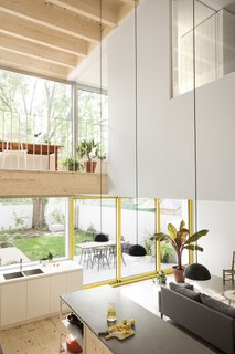  A study area on the mezzanine level overlooks the kitchen. Extensive glazing gives the ground floor living spaces a direct visual link with the courtyard and terrace. 

