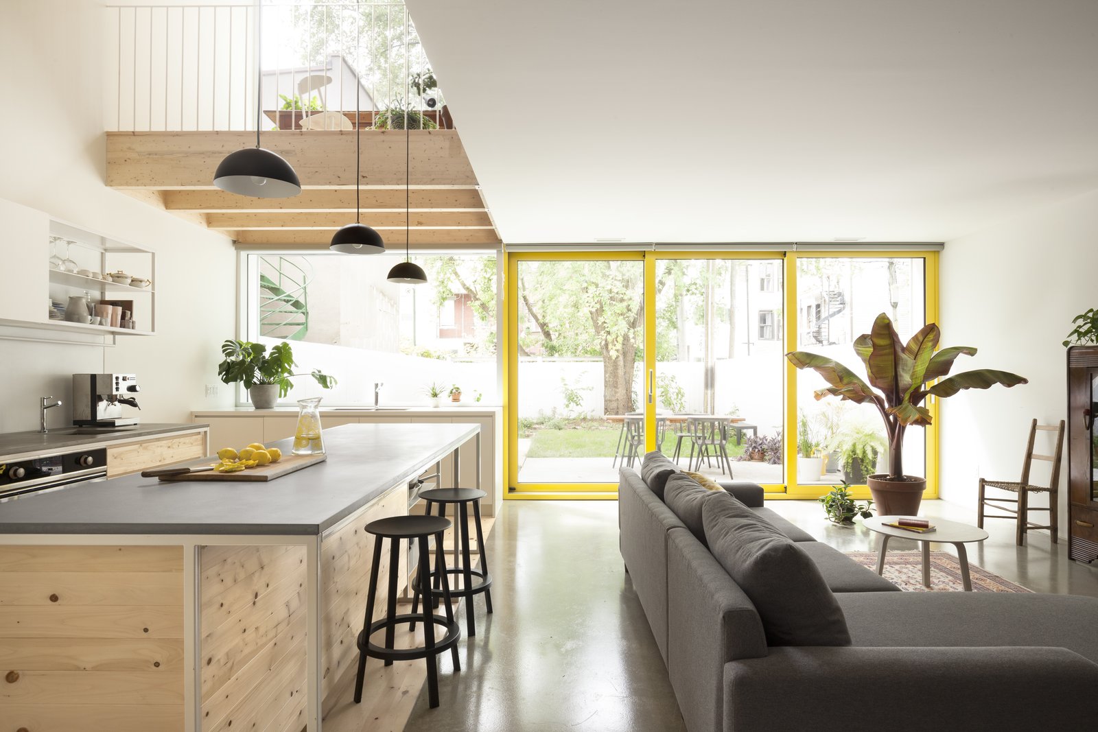 After: The kitchen faces the back garden and benefits from a double height atrium space. Pine has been used for the kitchen flooring and cabinets. Extensive glazing gives the ground floor living spaces a direct visual link with the courtyard and terrace.