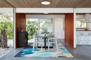 Some of this Eichler's original highlights remain, such as the tongue-and-groove redwood ceiling decking and the now re-stained luan wall paneling. In the kitchen, walnut is juxtaposed with crisp white, and the light blue found in the dining area is a unifying accent color.