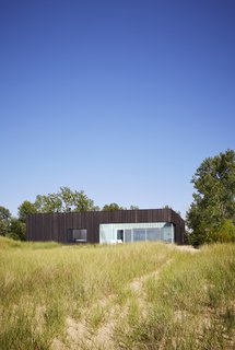 The exterior of the home is clad in charred wood siding, which pays homage to summertime bonfires on the beach. 

