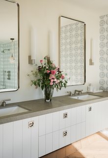 Modern bathroom vanities with a double sink are an added convenience for shared spaces. This one boasts expansive space between the two sinks and a hearty concrete countertop. 