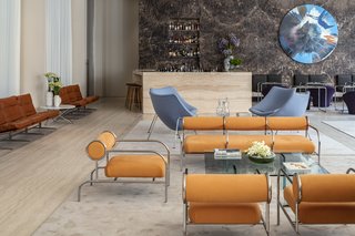 The lobby’s historic elements are juxtaposed with classic midcentury designs from Shiro Kuramata and Pierre Paulin together with artwork by Damien Hirst.