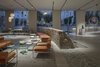 Modern home with Living Room, Bench, Chair, Coffee Tables, Sofa, Pendant Lighting, and Track Lighting. The bastion wall has been incorporated into the lobby's design. Photo 3 of Jaffa Hotel