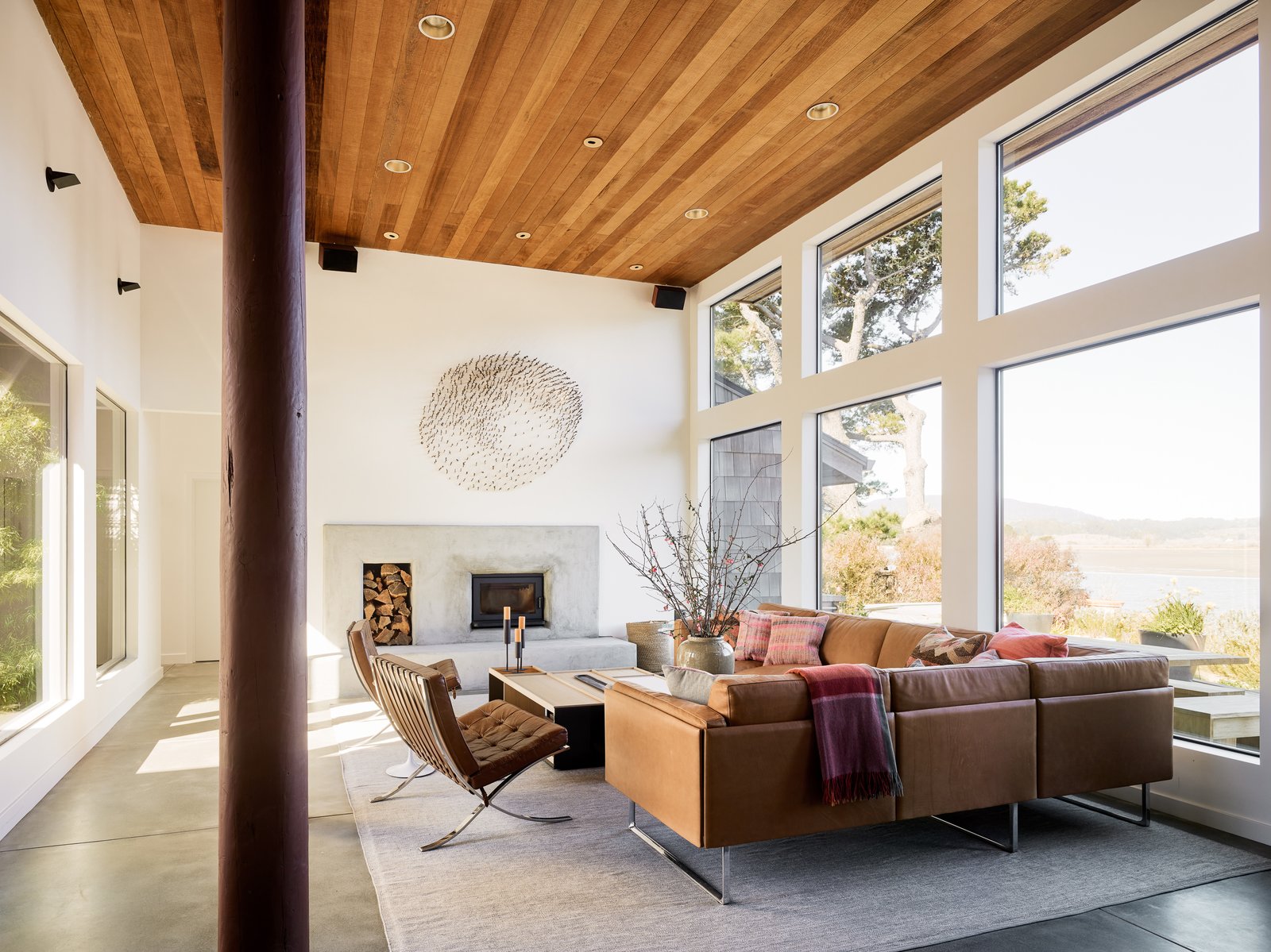The influence of the beach is echoed in the living room's sandy, stucco masonry. A wall of windows brings a sense of the outside in.