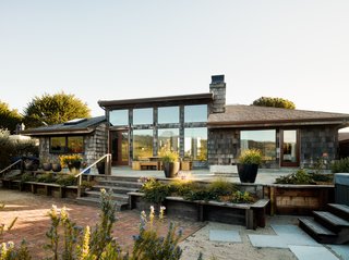 The Inlet House exterior is marked by cedar shingle wood siding and ample glazing that emphasizes the views and the feeling of living in a wildlife sanctuary.