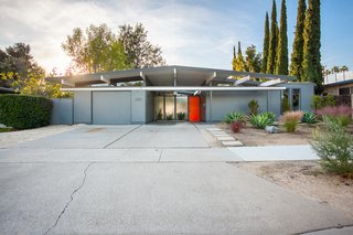 Classic post-and-beam construction and a bright orange door create a sunny facade for this updated Orange County Eichler.