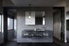 Modern home with Bath Room, Marble Counter, Dark Hardwood Floor, Pendant Lighting, Porcelain Tile Wall, Undermount Sink, and Wall Mount Sink. The minimalist bathroom provides a calm, introspective experience. Photo 9 of Oikos at Breakneck Gorge