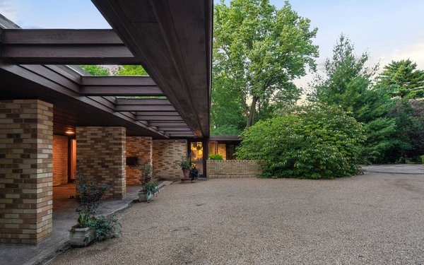 The flat roof cantilevers out over a stone walkway. 