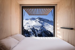 The minimalist interiors are clad in light wood paneling and feature large picture windows which frame the landscape and help integrate the "nests" into their setting. 