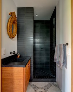 The guest bath features original brass-inlay terrazzo floors.