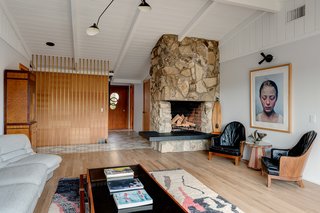 The main floor has a great room with a vaulted, tongue-and-groove ceiling and a dramatic stone-inlay fireplace. 
