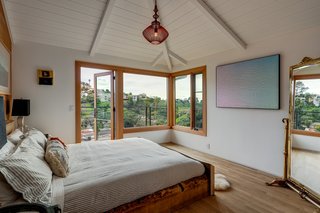 The principal suite has an open, airy feel thanks to the vaulted ceiling, picture windows, and a door leading to the outdoor terrace. 
