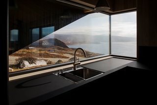 The butted-glass corner window brings panoramic views into the kitchen. 