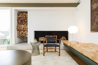 The living room has a wood-burning fireplace and a cut-out nook for firewood storage.