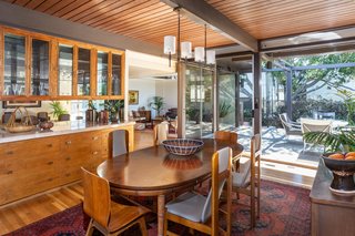 Sliding glass doors connect the dining area to a long deck that lines the exterior.