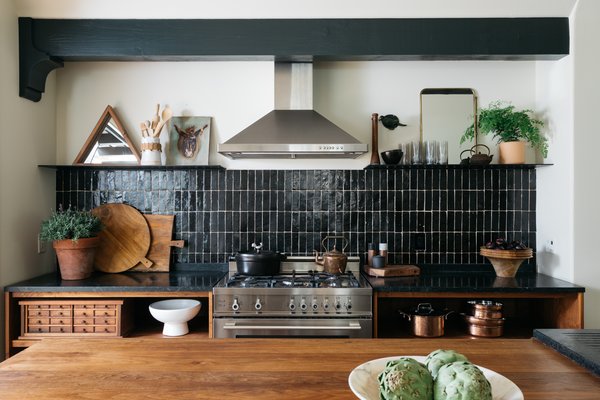 The owners of this updated Tudor-style abode in the Los Angeles neighborhood of Eagle Rock, Amanda and William Hunter, are the design duo behind the William Hunter Collective, which rehabs homes. Handmade tile, soapstone counters, walnut wood, and steel make up the artfully styled kitchen.