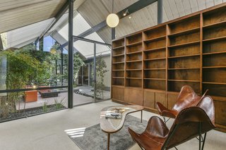 The room has two walls of built-in bookshelves and would make a lovely light-filled library.